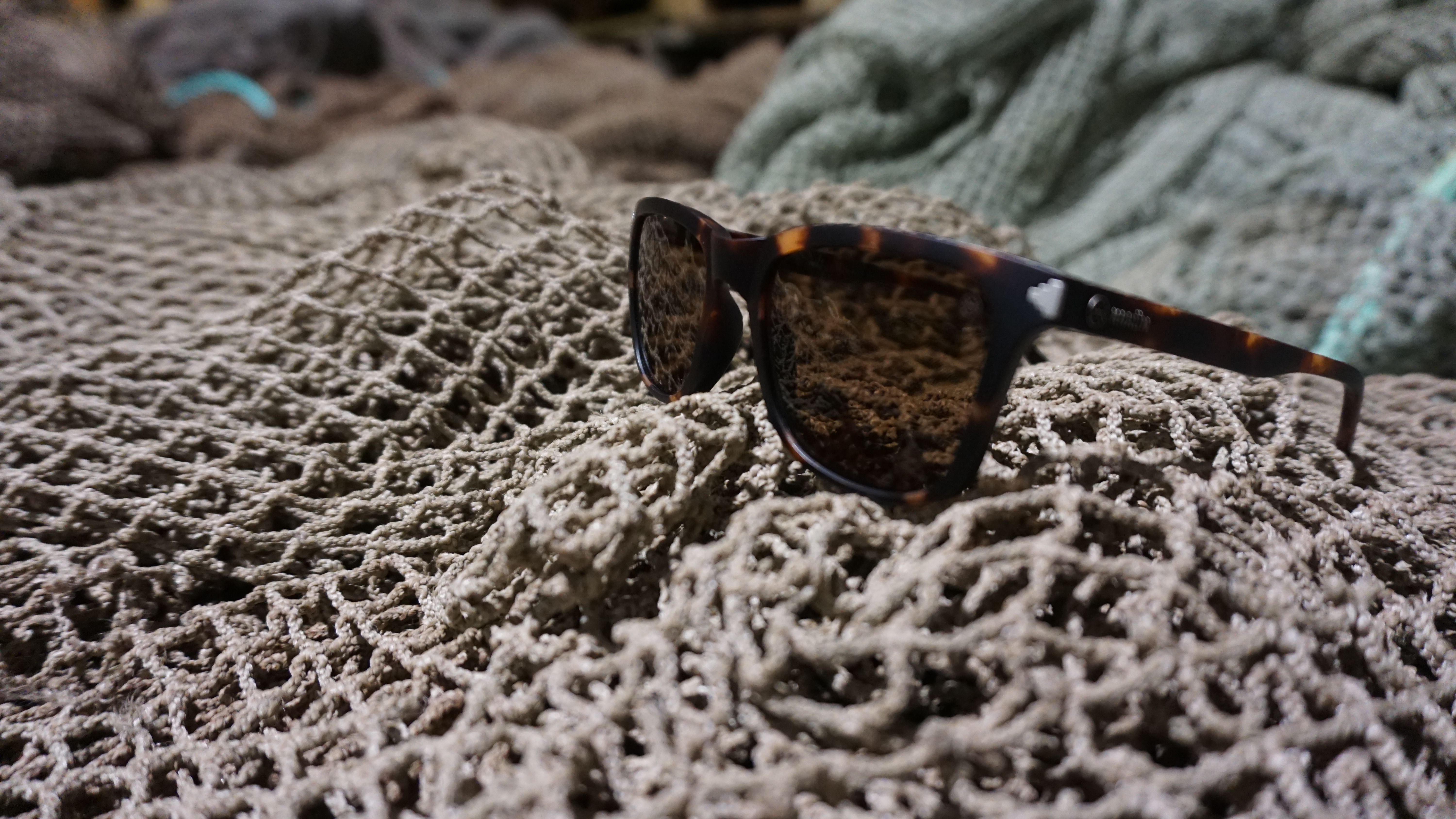 Fisketau i fokus med hav og fjell uklart i bakgrunnen. 